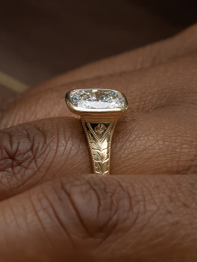 Custom engraved solitaire engagement ring with a reverse tapered band